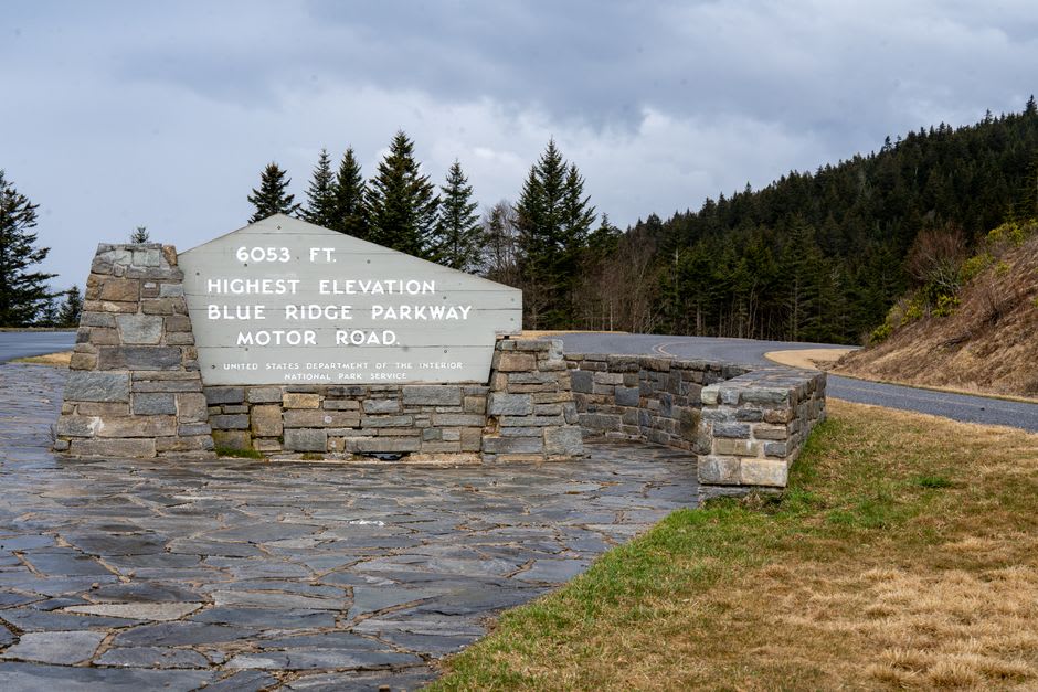 Sunlight breaking through a stone tunnel on the Blue Ridge Parkway with the road curving ahead