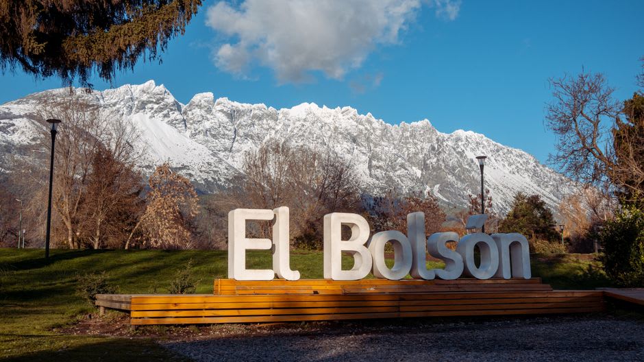 The artisan market in El Bolsón's central plaza with mountains behind