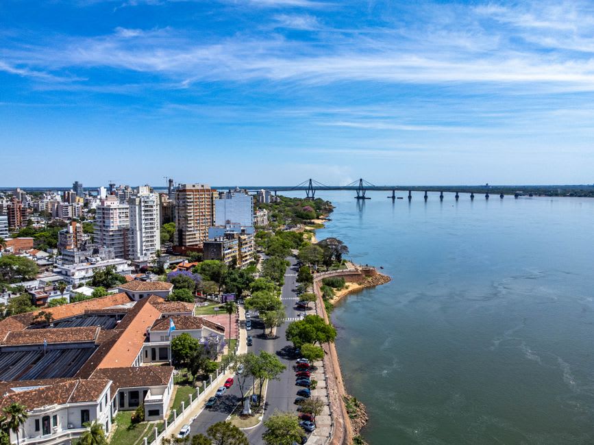 Vista elevada sobre el ancho río Paraná desde los acantilados del Parque Urquiza al atardecer