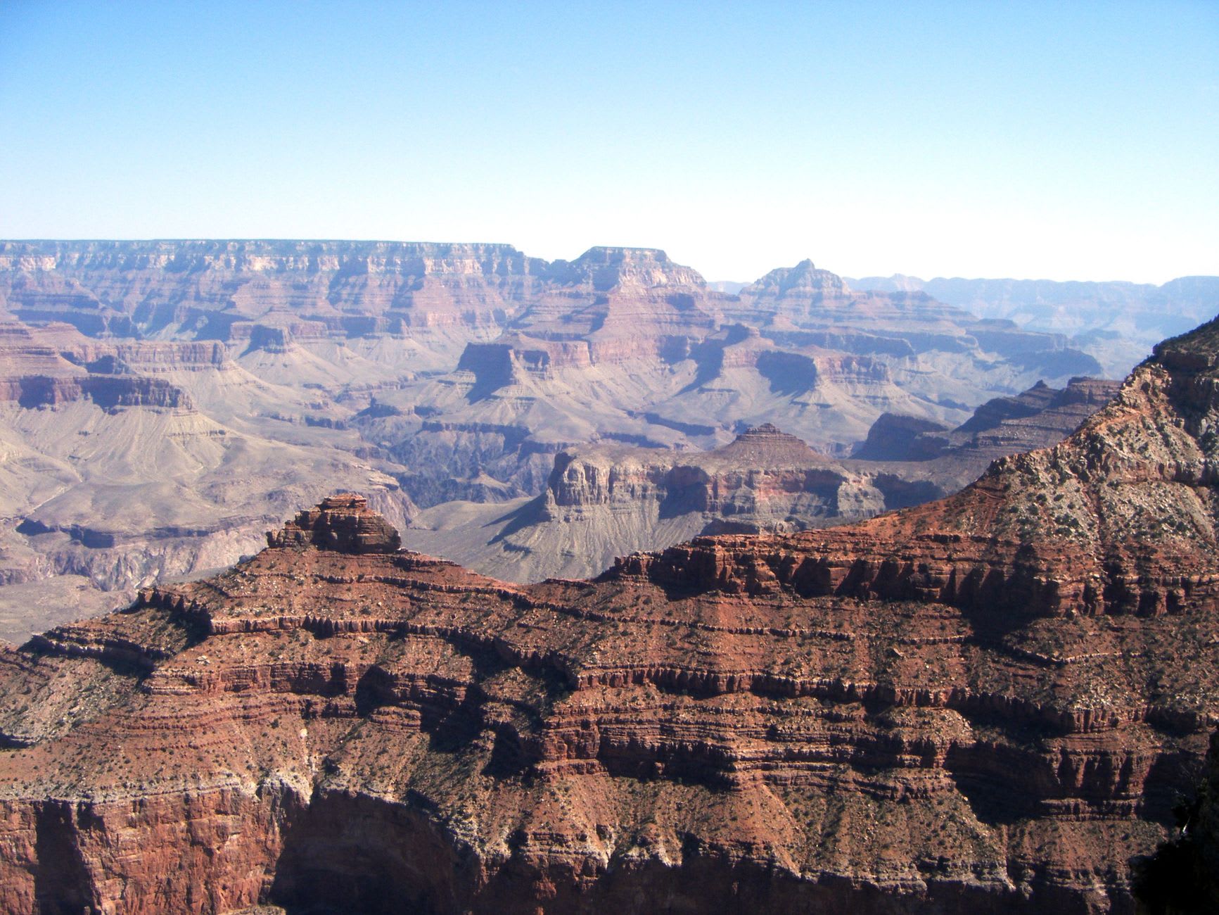 Le lever du soleil teintant les couches des parois du Grand Canyon d'un orange ardent