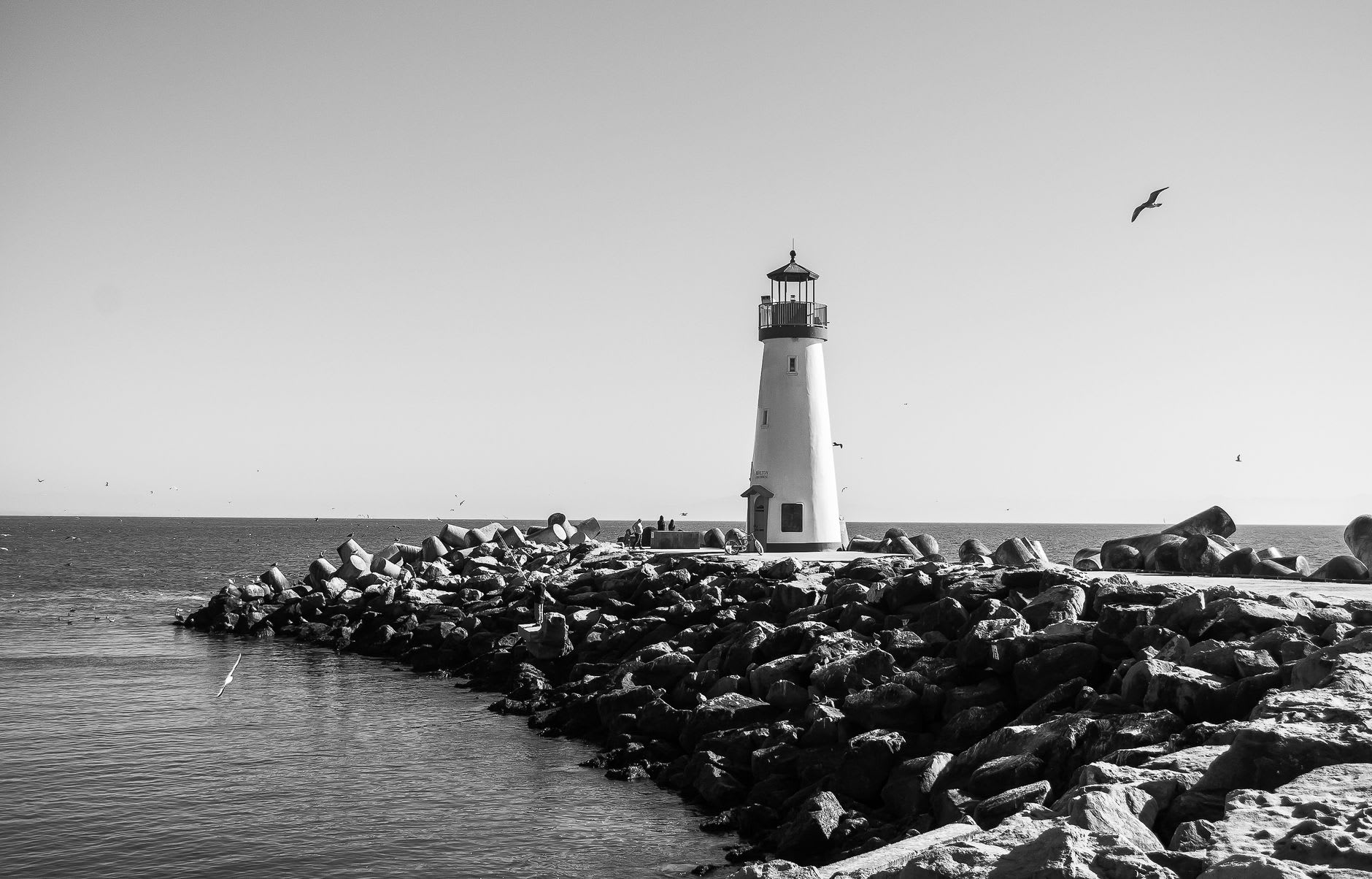 El Faro California con luz matutina con la costa volcánica abajo y el Caribe extendiéndose hasta el horizonte