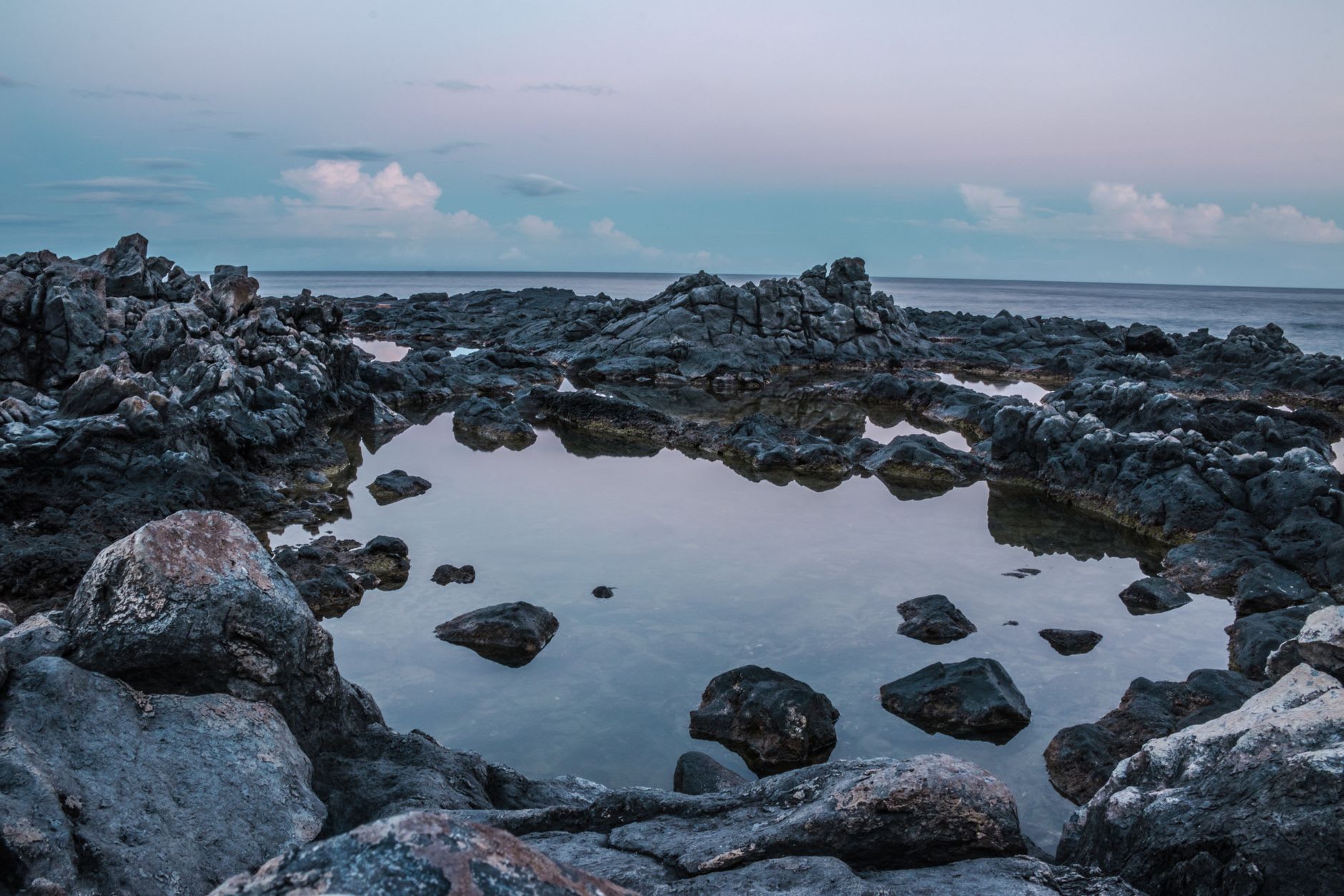 La piscina natural Conchi desde arriba — agua turquesa perfectamente contenida dentro de un círculo de roca volcánica negra