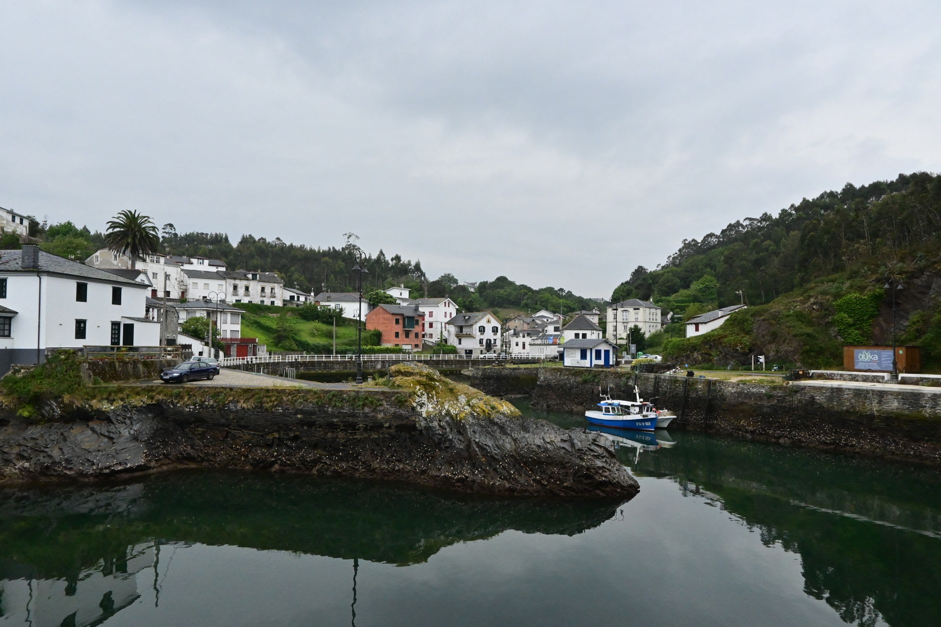 The Sella river estuary at Ribadesella in early morning, calm water reflecting the pastel facades of the old town