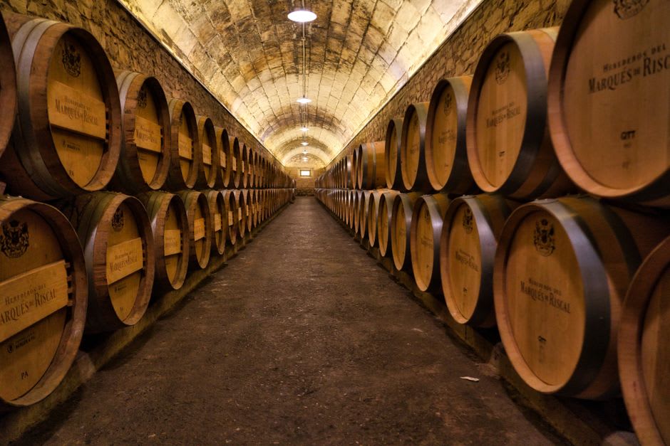Tinas de fermentación de madera y manos manchadas de tierra durante la vendimia en una pequeña bodega