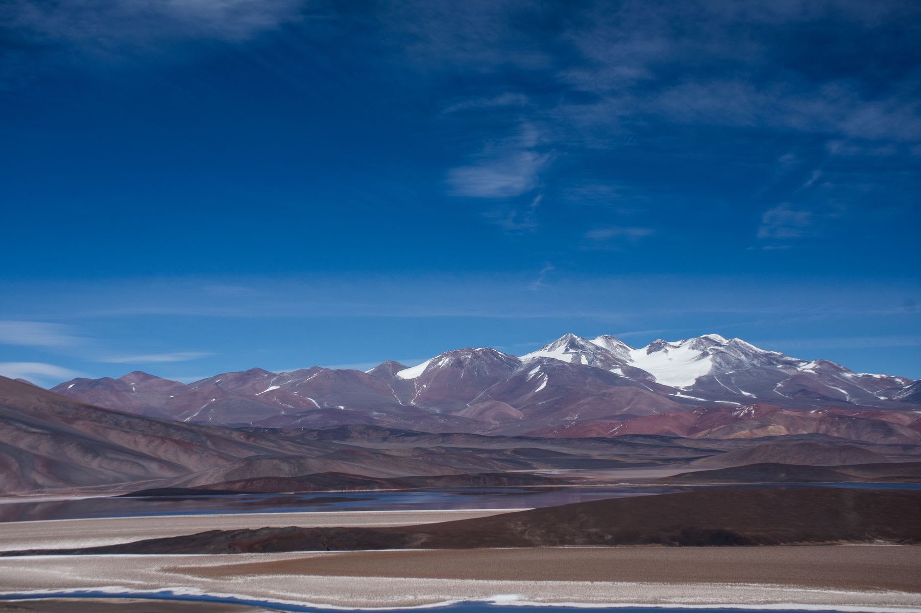 Laguna Miscanti at 4,200 meters with its turquoise water and volcanic peaks perfectly reflected in the still surface