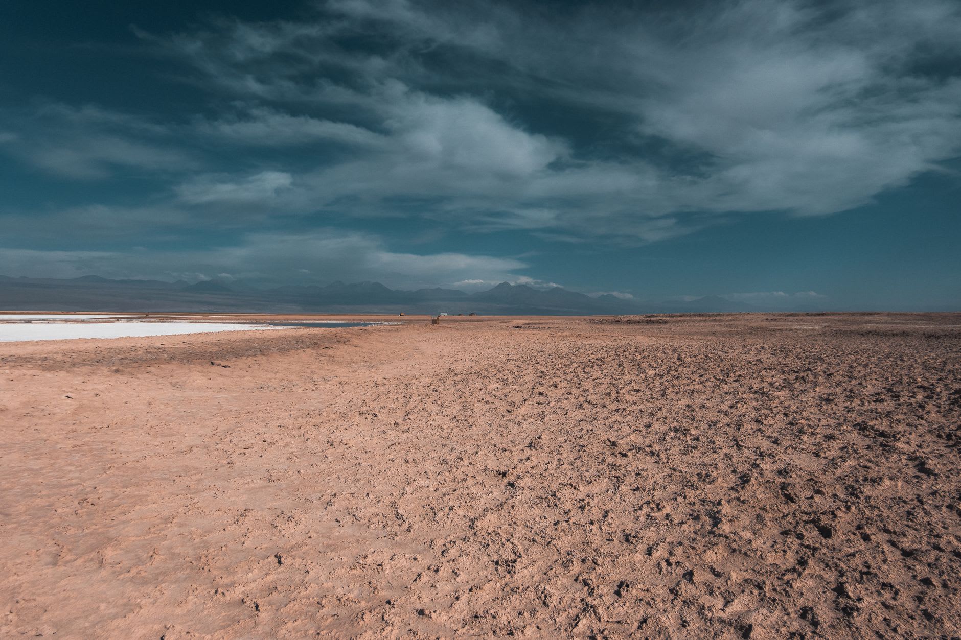 The Salar de Atacama meeting the base of the Atacameño Andes in the clear afternoon air, mountains reflected in a thin film of brine