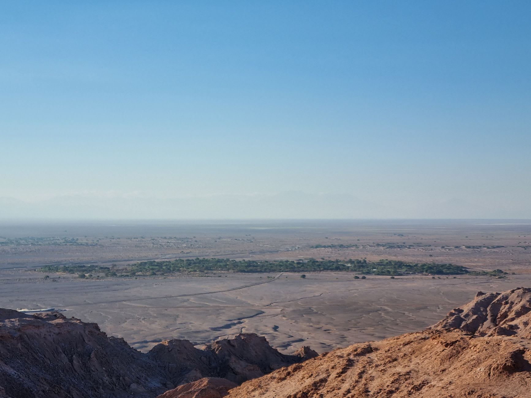 San Pedro de Atacama's adobe streets glowing golden in afternoon light with the Andes rising in the distance