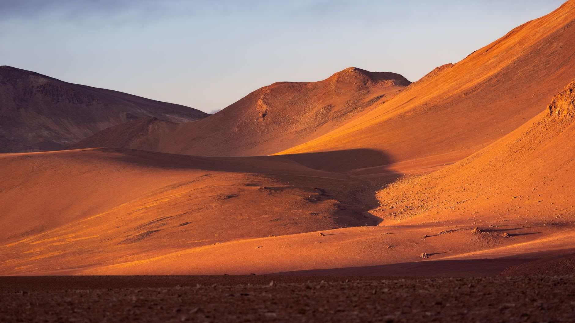 La place en liparite blanche de Toconao brillant dans la lumière de l'après-midi avec le clocher colonial se dressant contre le ciel bleu