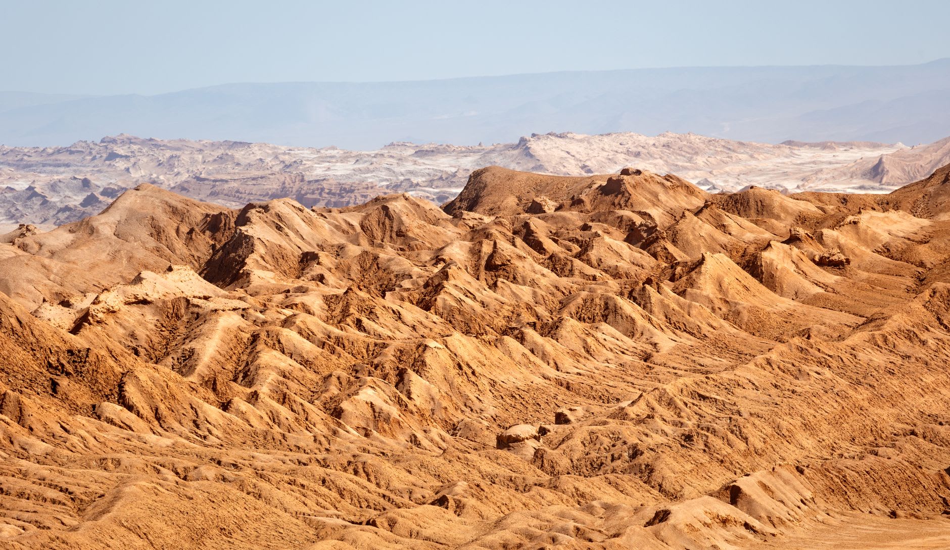 The red crescent dune of Valle de la Muerte in the afternoon light, boot tracks visible on its steep face
