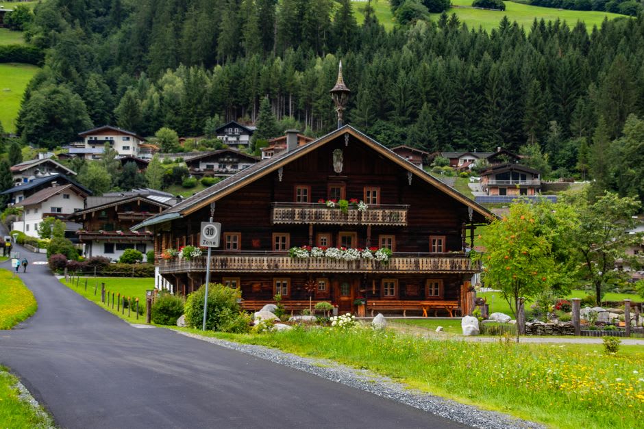 A wooden farmhouse chalet in Grän village with the Tannheim Mountains rising behind it