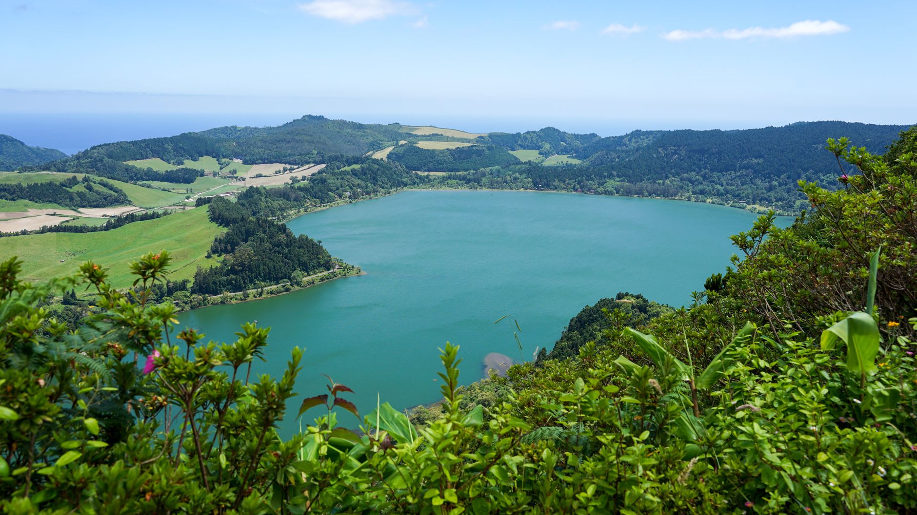 Lagoa do Fogo appearing through clearing cloud mist, the crater lake deep blue and completely undeveloped