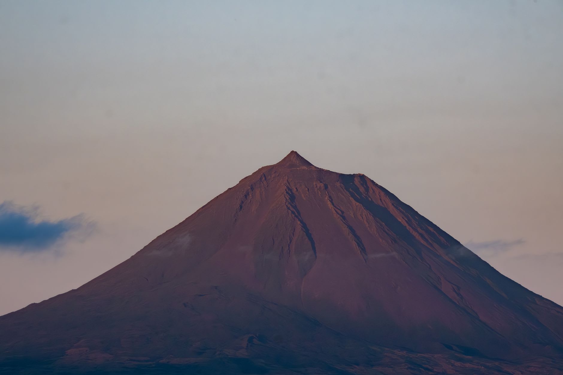 Black lava stone vineyard walls of Pico Island's UNESCO wine landscape stretching to the sea
