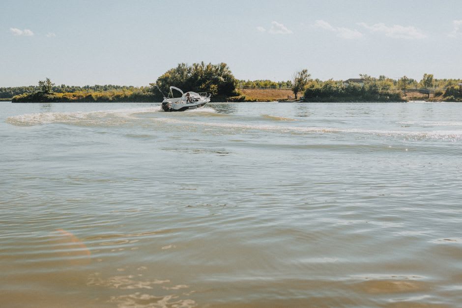 A guide poling a flats skiff across shallow bonefishing water on Acklins under a wide open sky