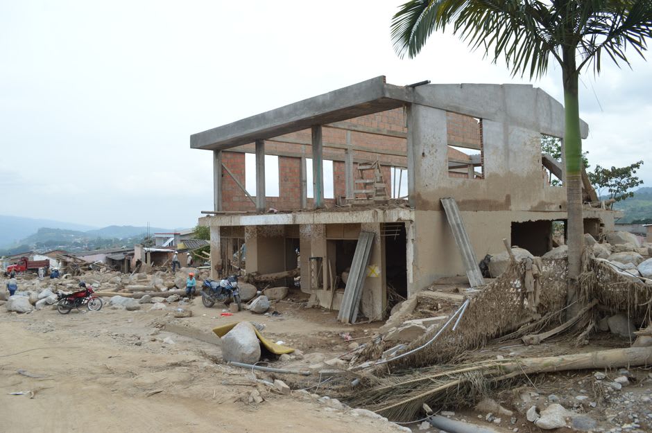A rebuilt house in Duncan Town, Ragged Island, freshly painted next to the storm-damaged shell of a neighboring building