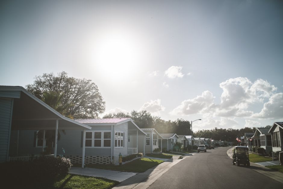 A neat residential street in Spanish Wells with well-kept houses, manicured lawns, and a golf cart parked in a driveway