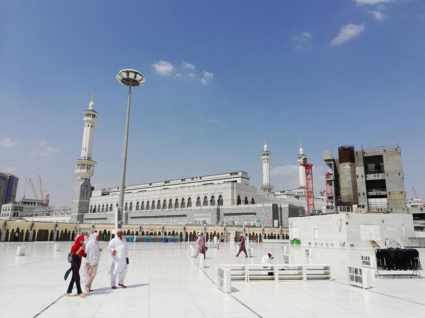 Cour extérieure de la Grande Mosquée Al Fateh avec sa façade en marbre blanc et son haut minaret à l'heure dorée