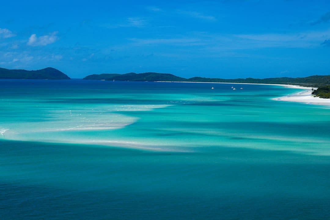A kayak resting on a white sand beach along Bahía Concepción with small desert islands scattered across the calm turquoise bay