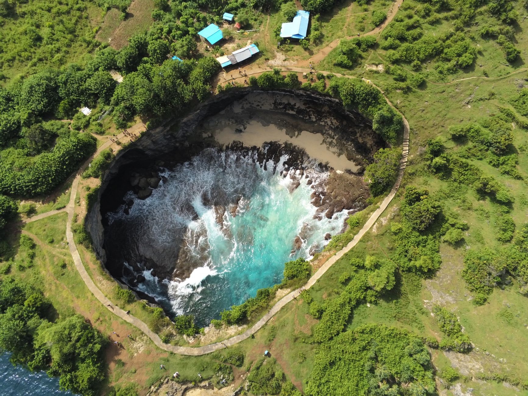 Manta rays gliding in clear turquoise water at Manta Point off Nusa Penida's southwest coast