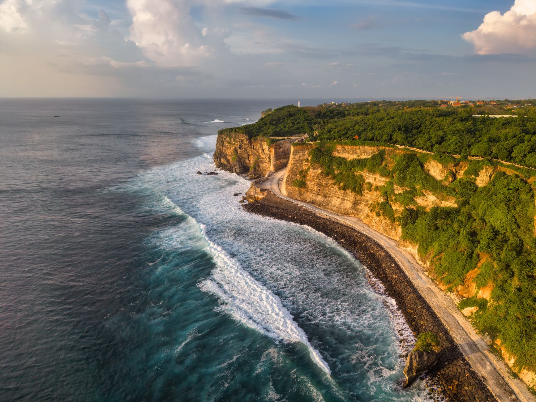The Indian Ocean stretching to the horizon from the clifftop path of Pura Luhur Uluwatu, the sea vivid blue in afternoon light