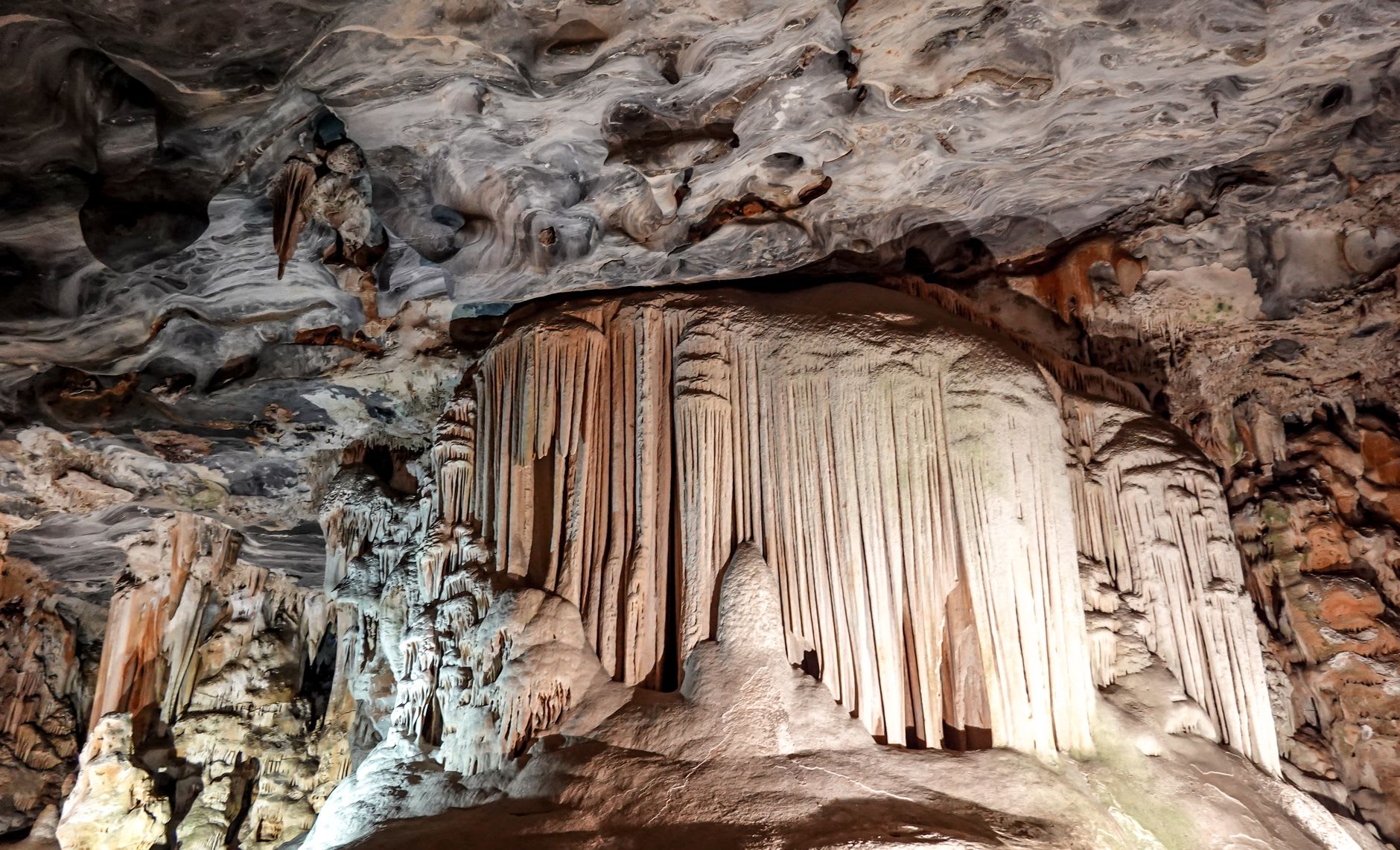 Massive stalactites and limestone formations inside Wind Cave illuminated by walkway lighting at Mulu