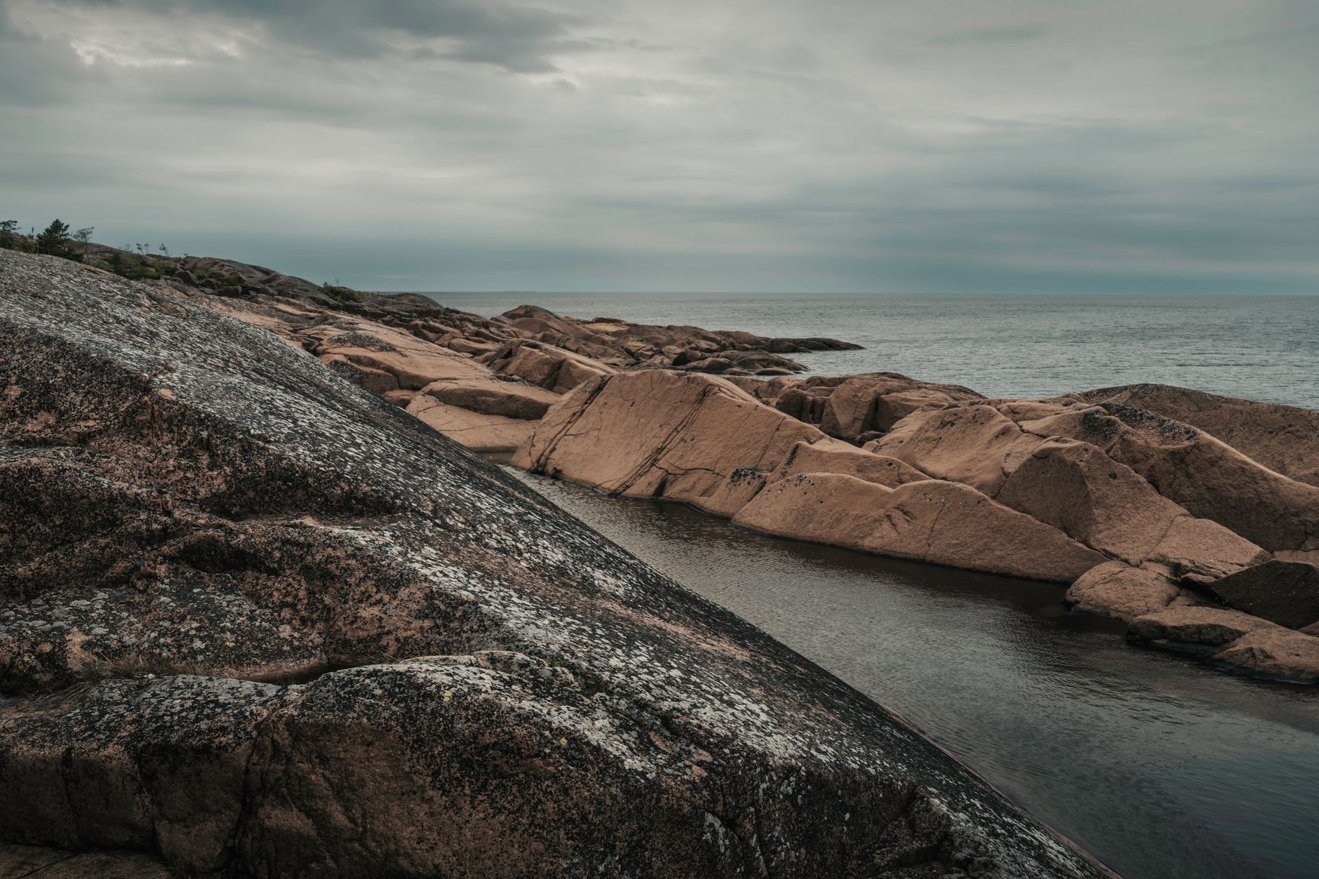 El faro de Dueodde elevándose sobre los pinos en el extremo más meridional de Bornholm, visto desde la playa de abajo