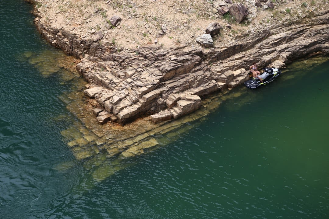 Sheer sandstone canyon walls rising from the turquoise water of Lake Furnas near Capitólio