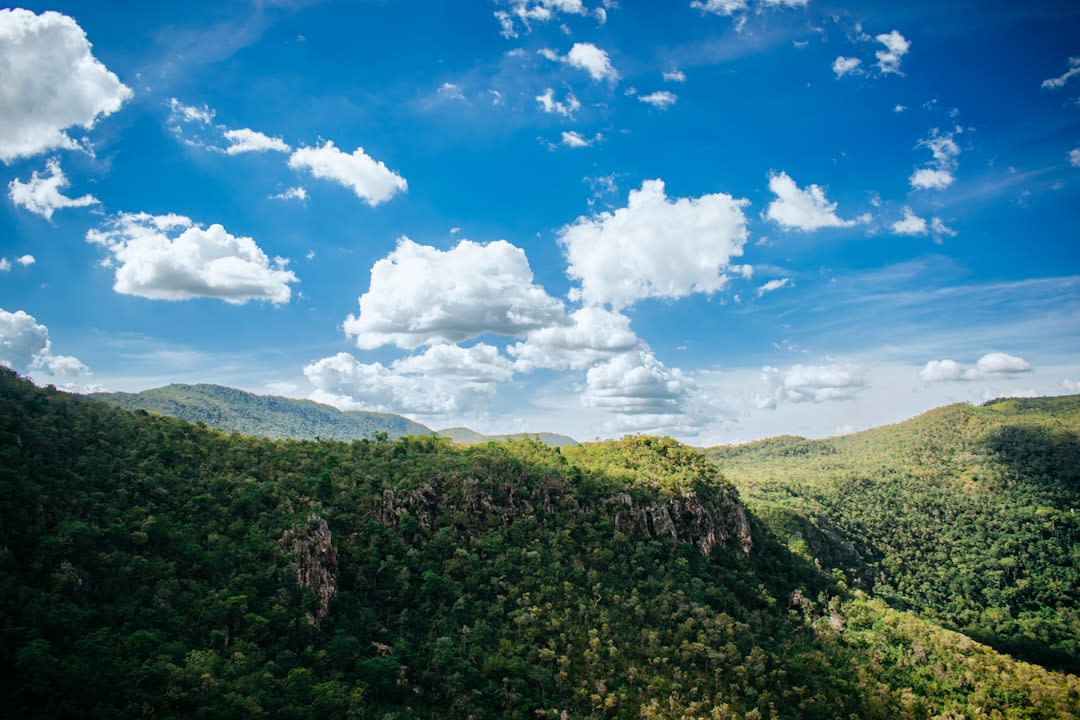 A hiker standing at the edge of a red sandstone mesa in Chapada das Mesas National Park near Carolina