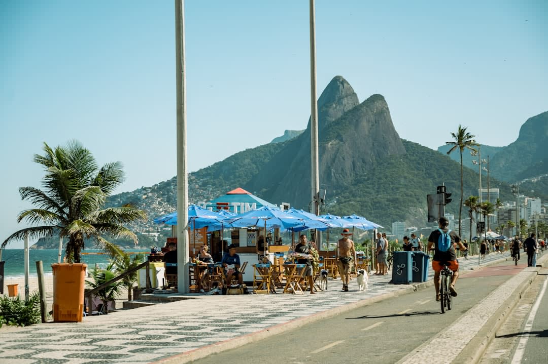Ipanema beach with beach umbrellas and the twin peaks of Dois Irmãos rising behind