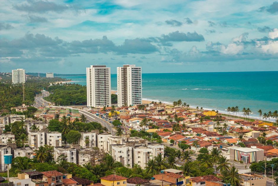 Jangada sailboats anchored over the turquoise reef pools off Pajucara beach in Maceio