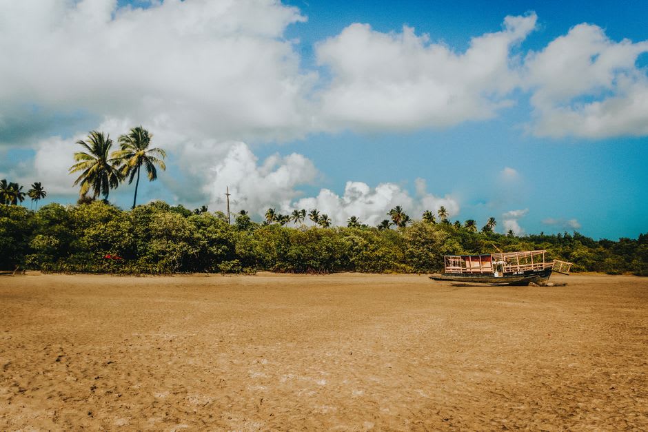 Golden hour light over white sand dunes at Mangue Seco with the village visible below