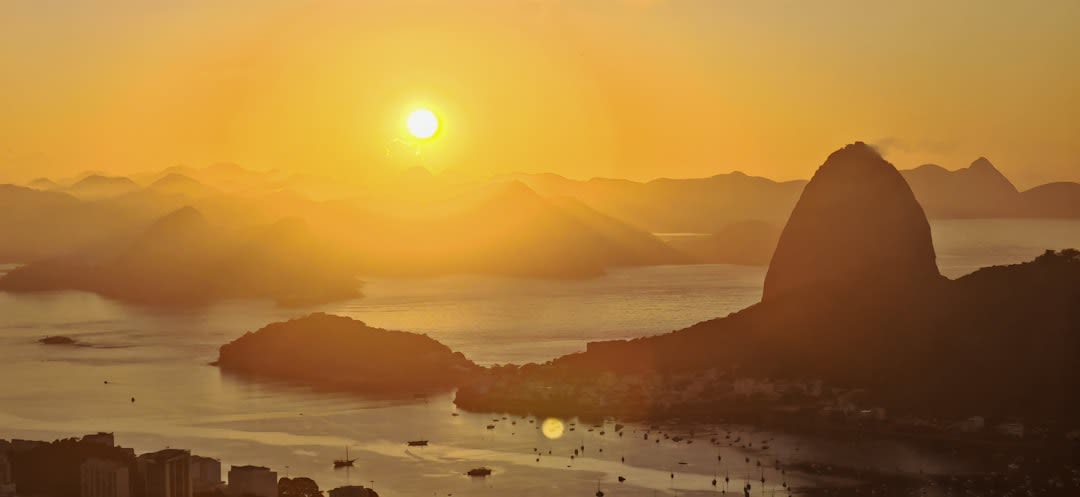 Vista desde la cima del Pan de Azúcar a la hora dorada mirando hacia el Corcovado y las playas de Río