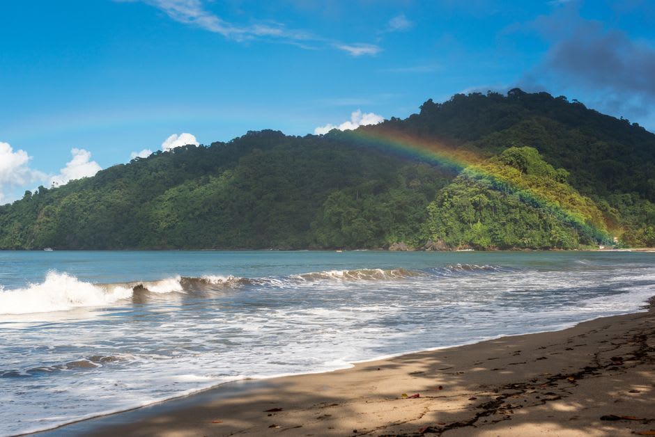 Brewers Bay's quiet stretch of sand on Tortola's north shore with steep green hills rising behind and clear water lapping the beach