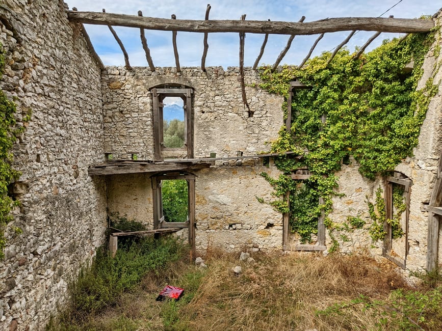 Overgrown stone ruins of an old sugar and rum works at the western end of Brewers Bay, half-covered in vines and sea grape