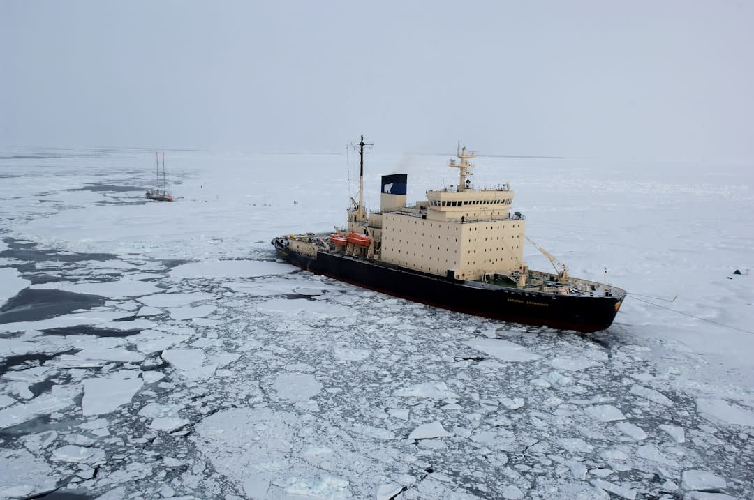 Inuit hunter in a small boat navigating between ice floes off Baffin Island's coast