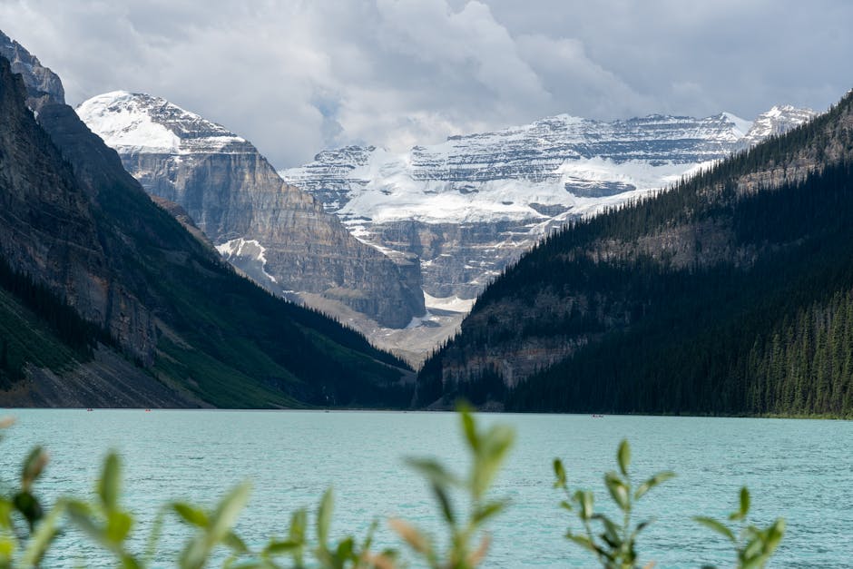 Turquoise glacial lake surrounded by snow-capped Rocky Mountain peaks