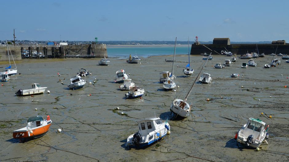 Fishing boats resting on exposed mudflats at low tide in a Bay of Fundy harbour