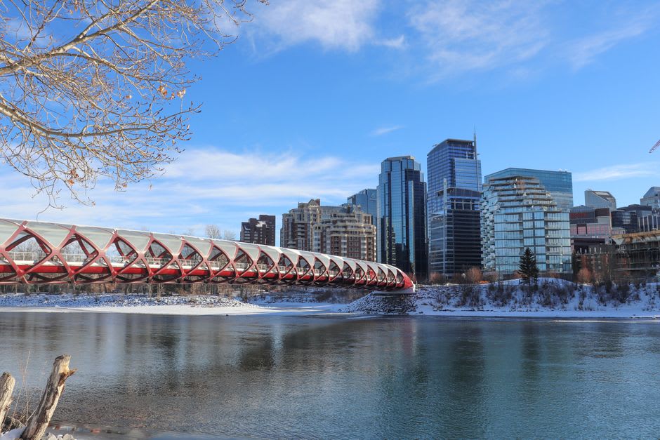 Calgary's downtown skyline reflected along the Bow River pathway at dusk