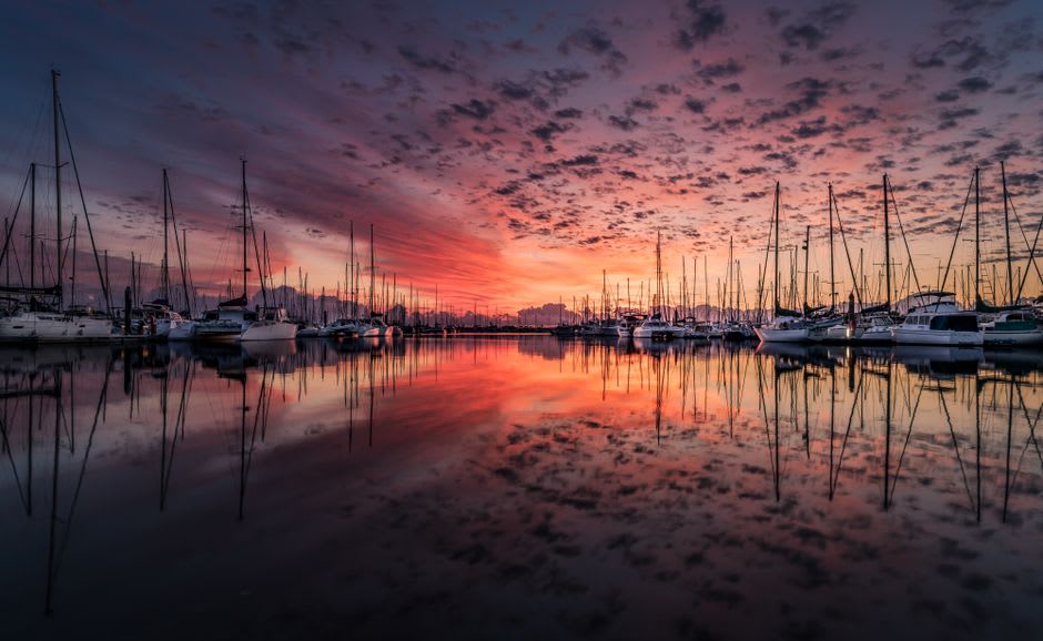 Sailboats moored in Charlottetown's harbour at sunset