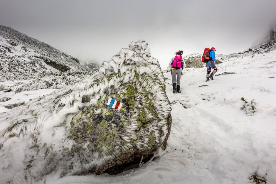 Hikers climbing the rocky trail to the summit of Brimstone Head on Fogo Island