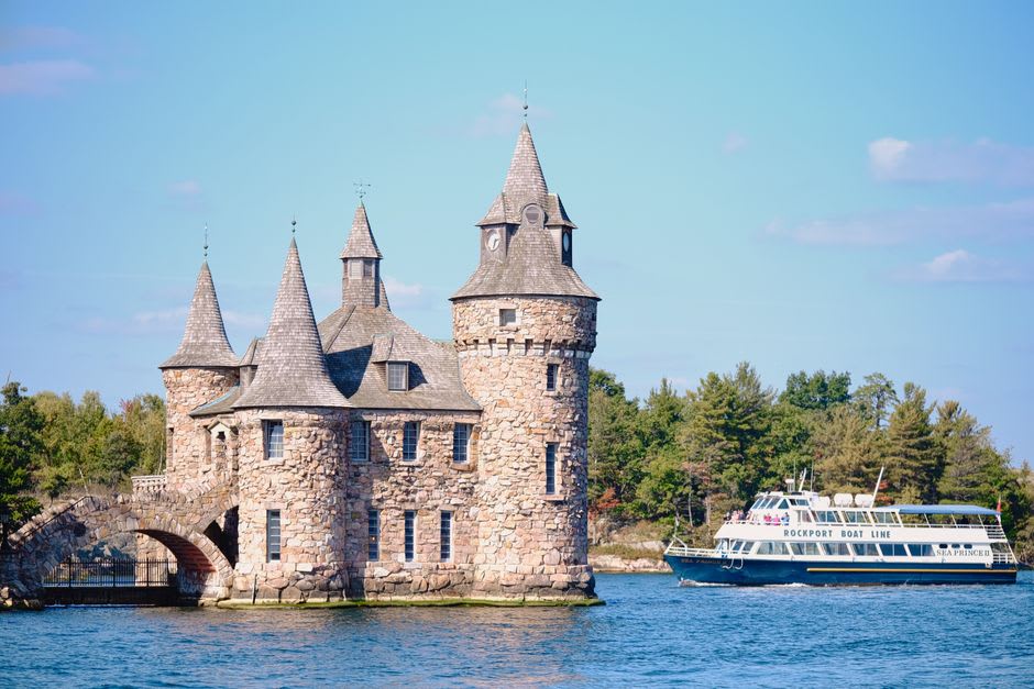 Boat tour weaving between small forested islands at the edge of the St. Lawrence River near Kingston