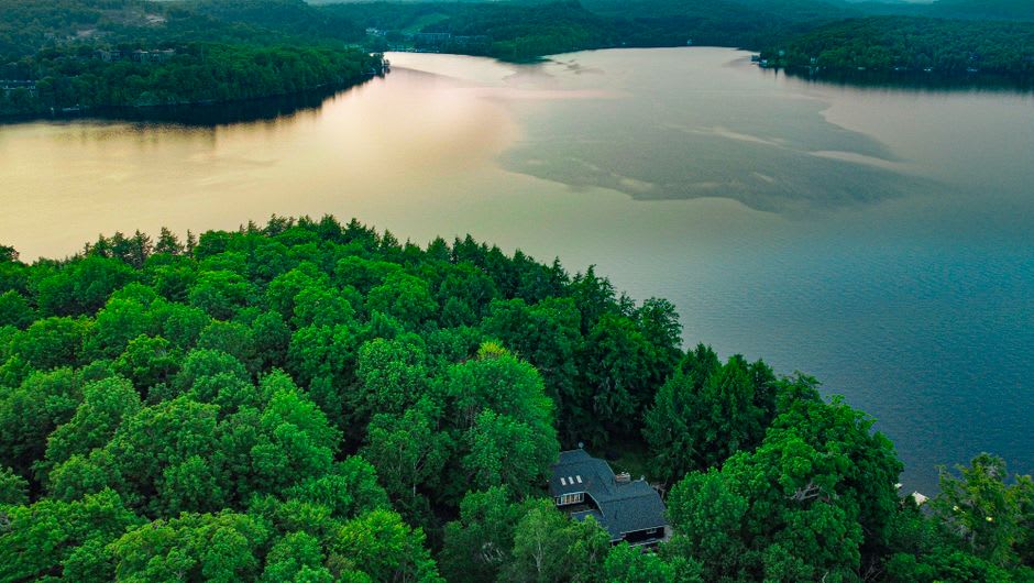 Historic steamship cruising across a Muskoka lake surrounded by pine forest