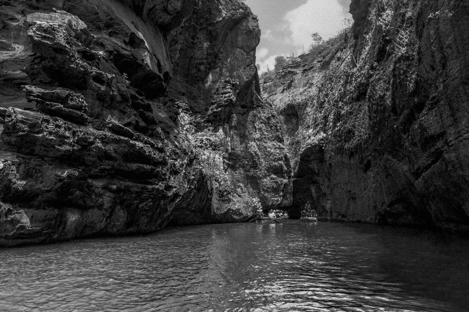 Canoeists paddling through a deep limestone canyon on the South Nahanni River