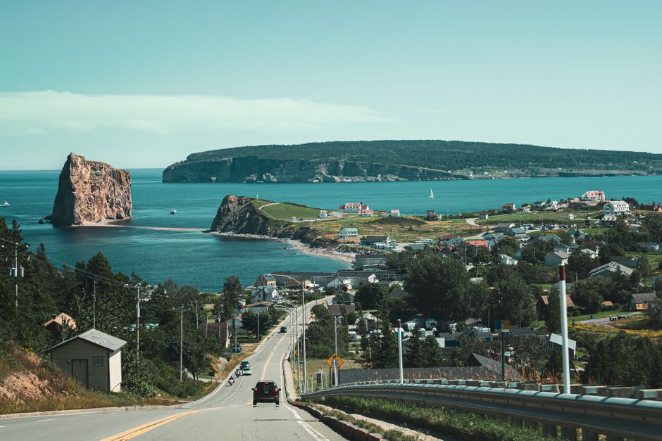 View of Percé's harbor and colorful village buildings with the rock visible offshore