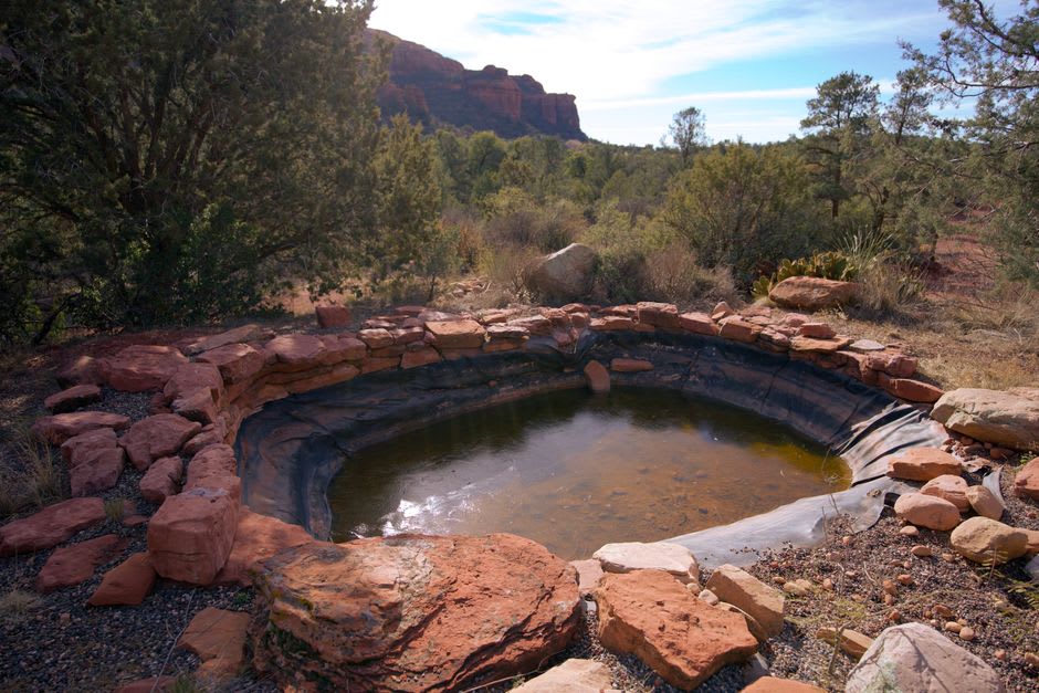 Steam rising from the hot pool at dusk with canyon walls glowing orange in the fading light