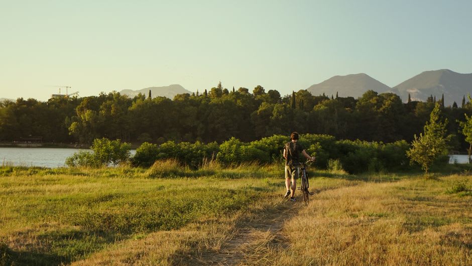 Cyclists and joggers along the Meewasin Valley trail beside the South Saskatchewan River at sunset