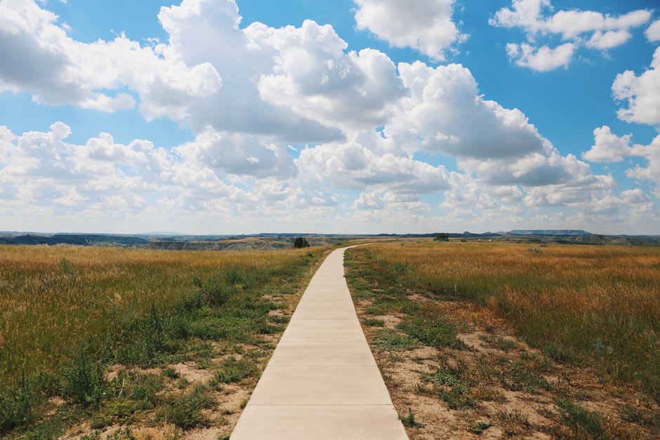 Grass-covered plains and interpretive trail markers at Wanuskewin Heritage Park north of Saskatoon