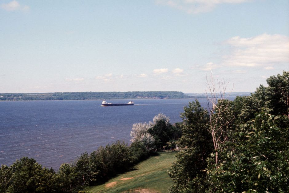 Container ship passing along the wide St. Lawrence River near Trois-Rivières