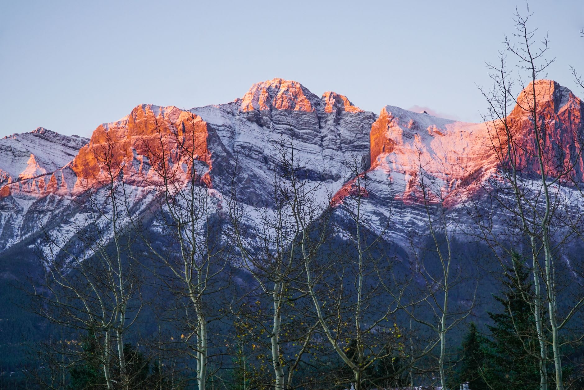 Ciclistas de montaña en un sendero de cresta sobre Canmore con el Valle Bow y las Tres Hermanas visibles abajo