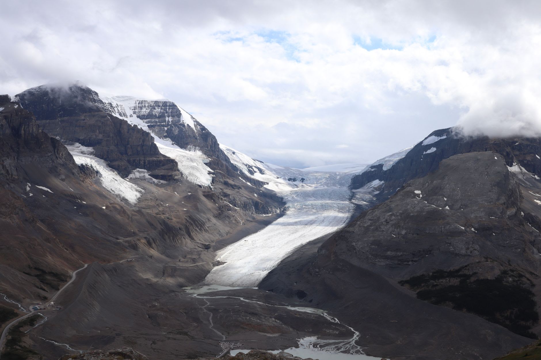 The Columbia Icefield viewed from the Icefields Parkway, a white expanse of ancient ice between peaks under a grey sky
