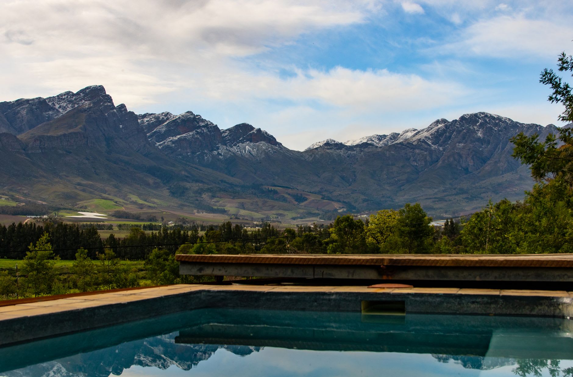 Banhoek Valley in autumn with copper-coloured vines filling the narrow valley floor and granite peaks above